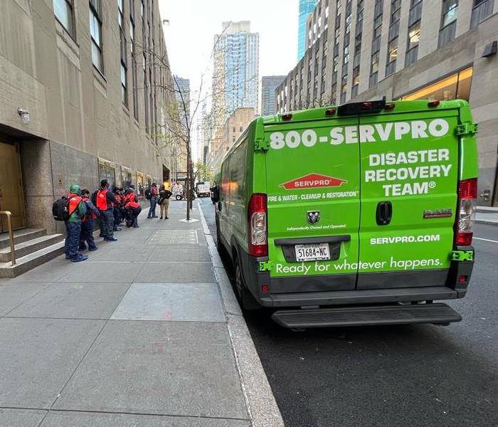 SERVPRO vehicles parked outside of a multistory building.