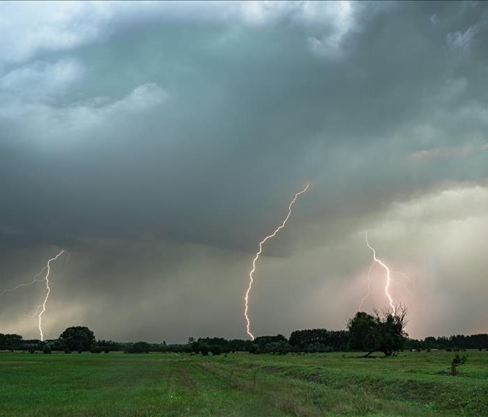Several lightning bolts strike down from a severe thunderstorm